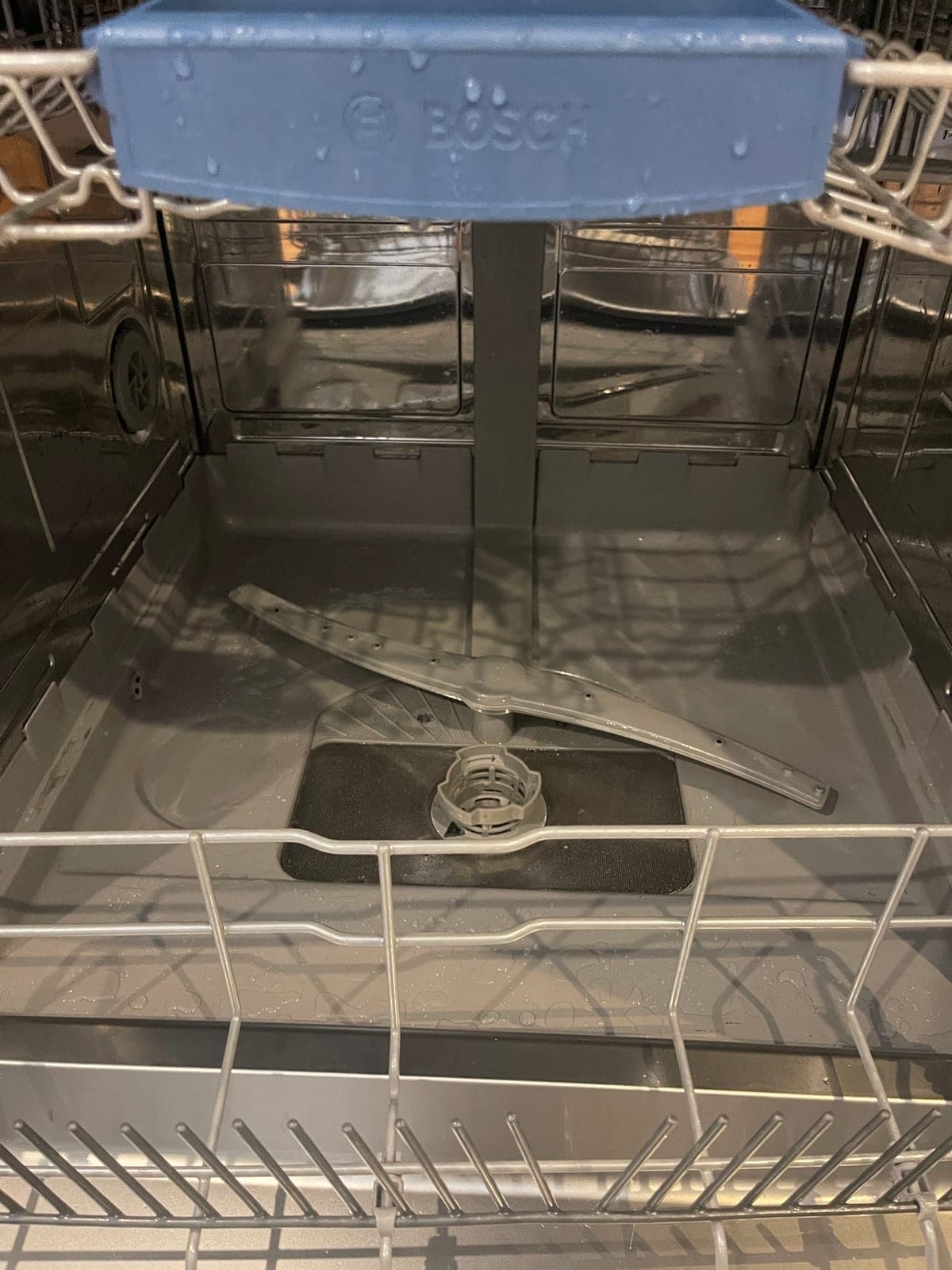The inside of a dishwasher tub after a deep clean — sanitised, no residue, no odour.