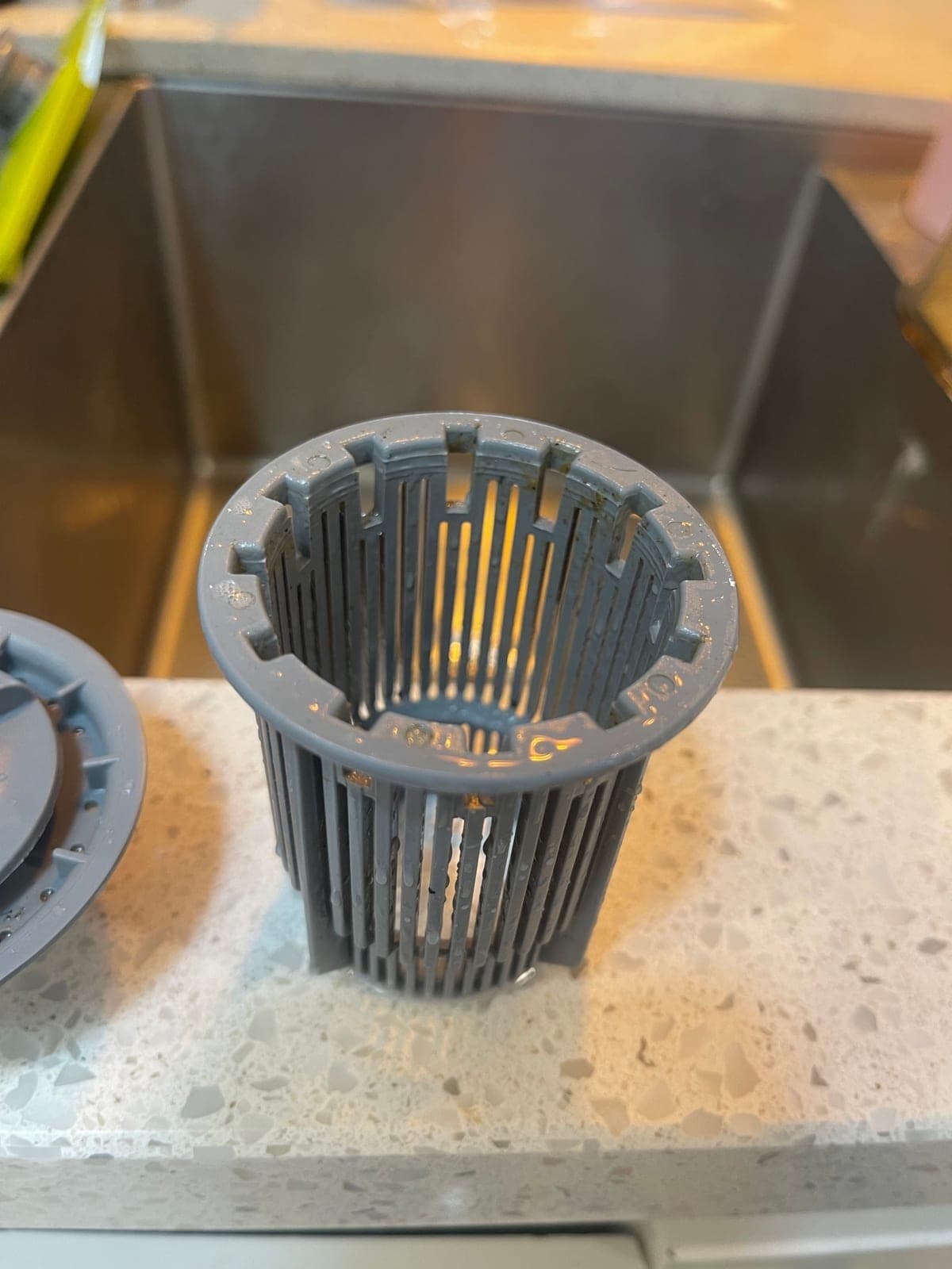 The same dishwasher filter after cleaning, back to bare plastic.