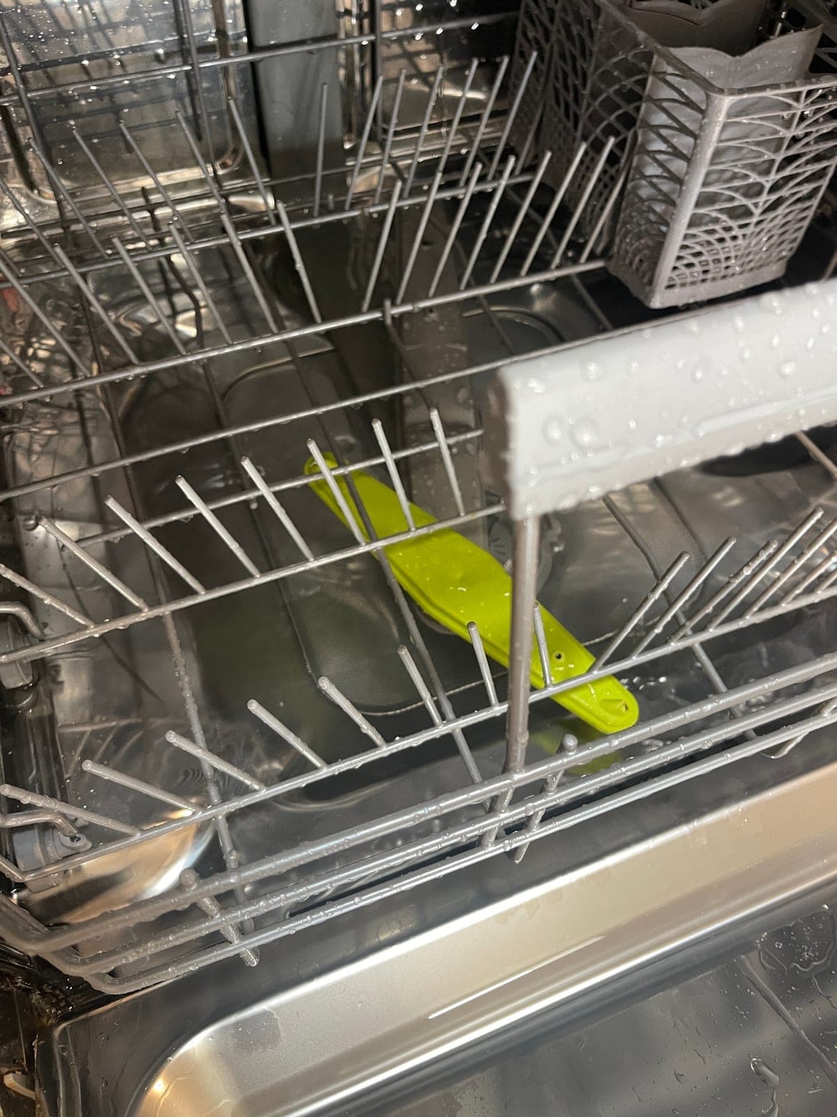 The racks of a dishwasher after a clean, with no residue left on the tines.