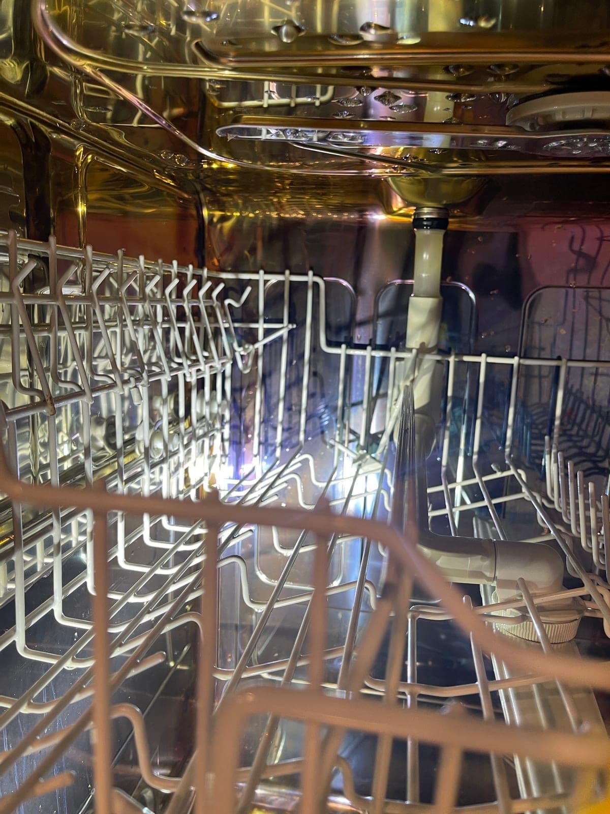 The racks and interior of a dishwasher after a full clean.