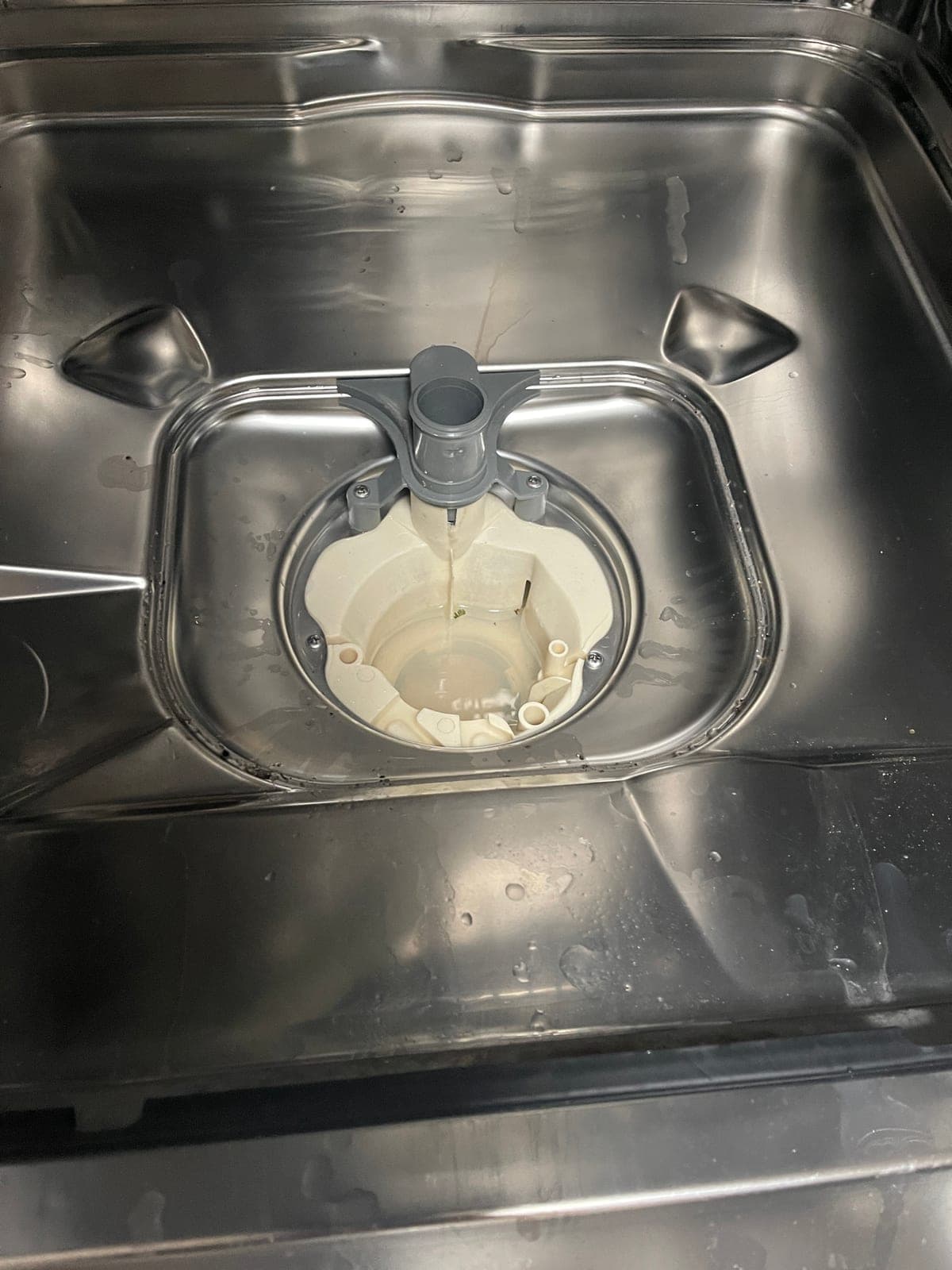 The sump housing of a dishwasher with the filter removed.