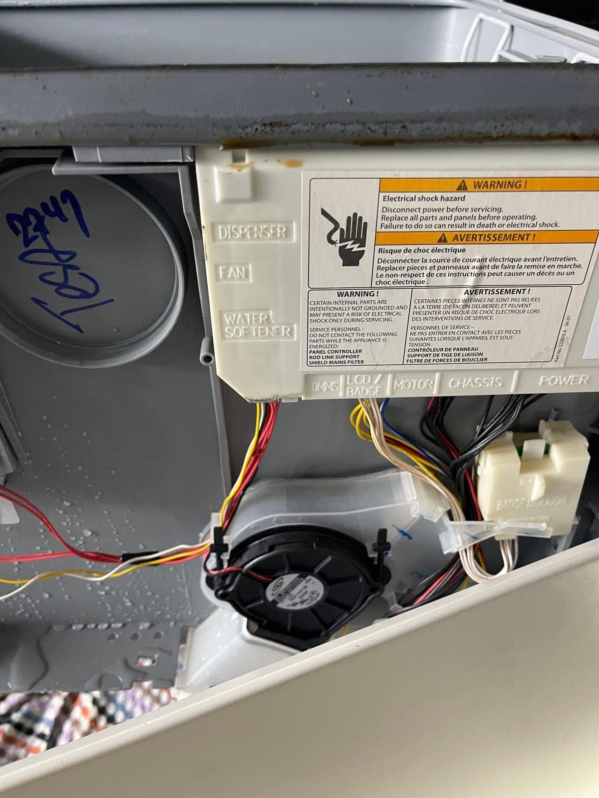 The base of a drawer dishwasher opened up to find the source of a leak.