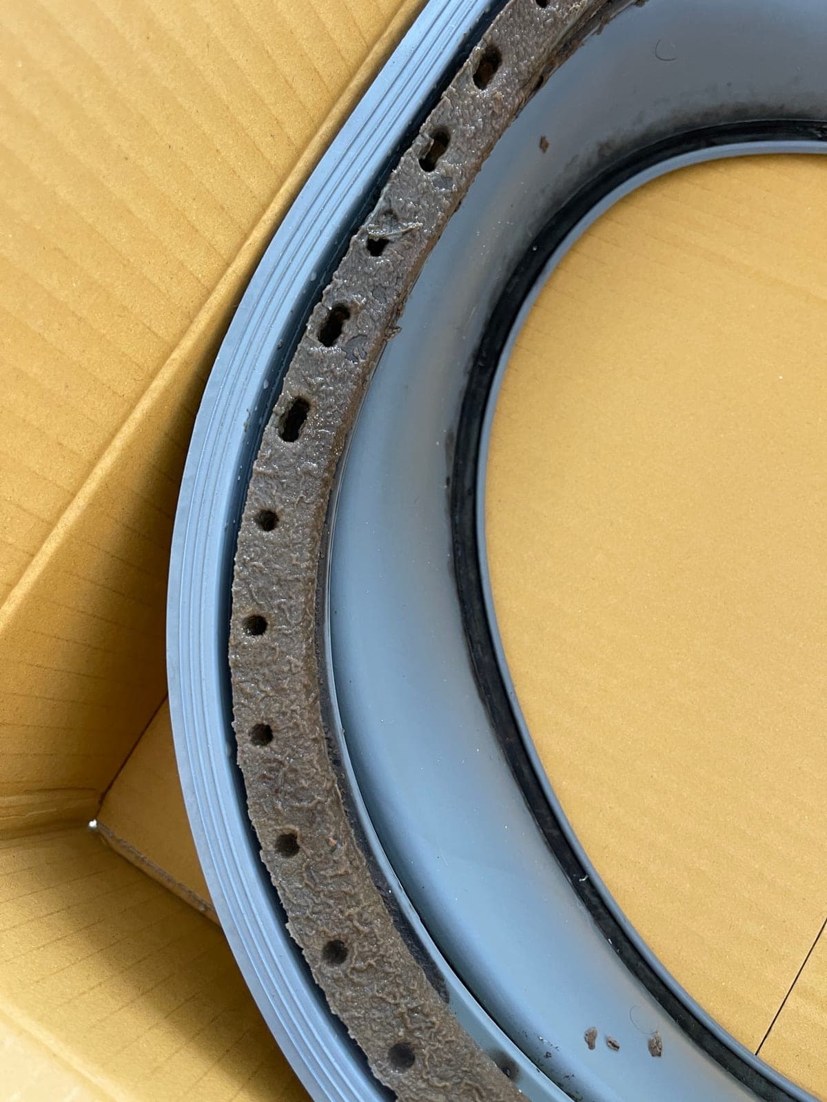 Detail of a door seal's mounting holes and clamp channel.