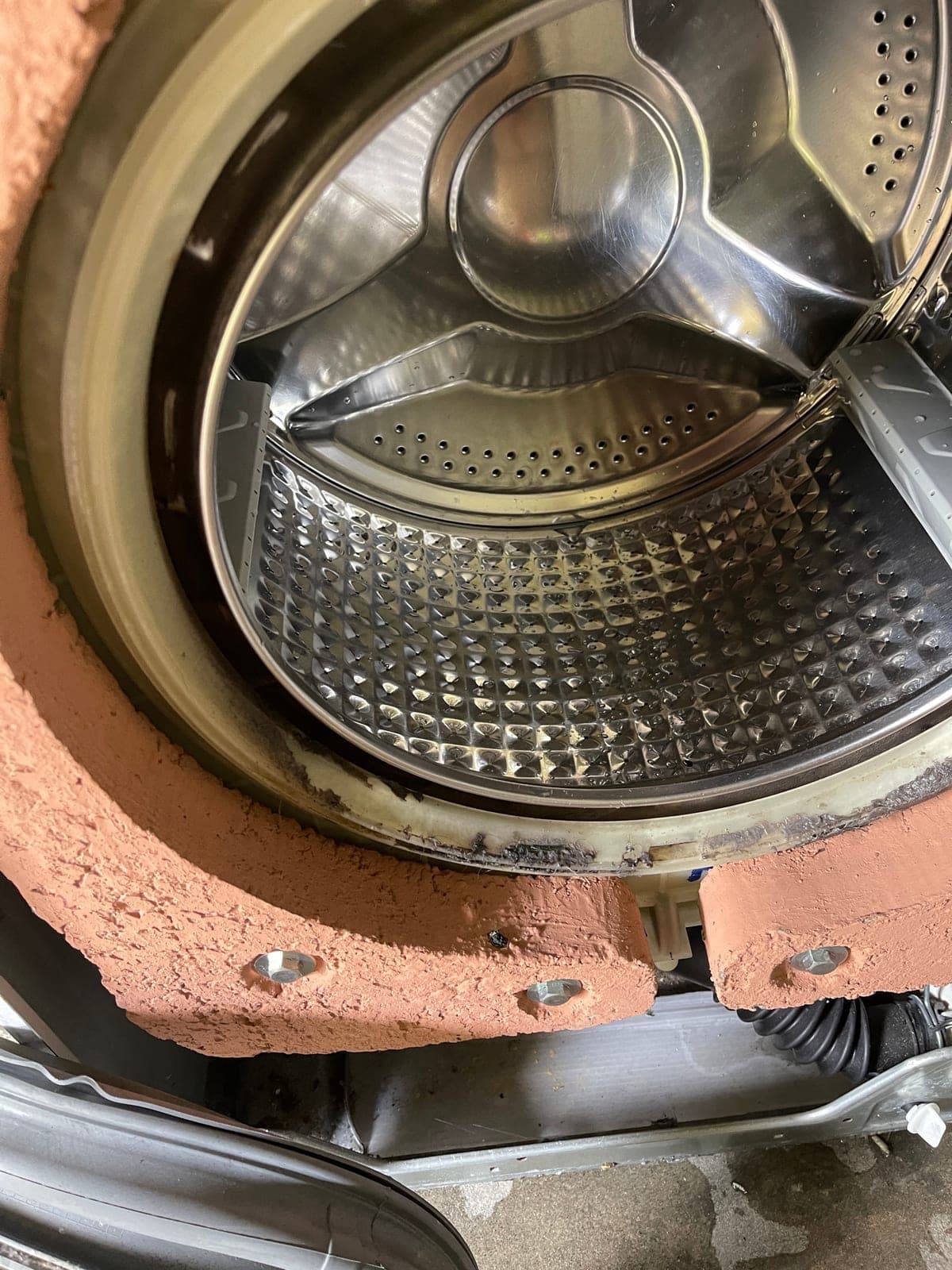 The outer tub and drum lifted out of a washing machine cabinet.