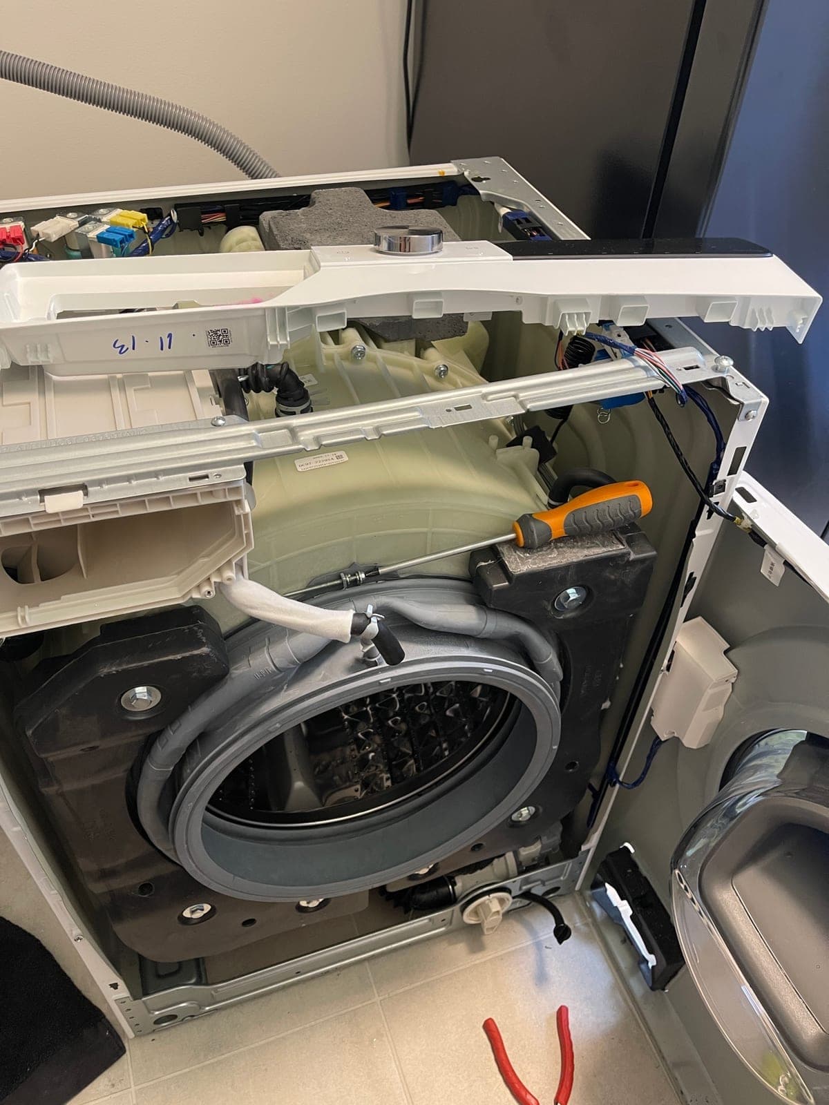A front loader opened at the top and front for a door seal replacement.