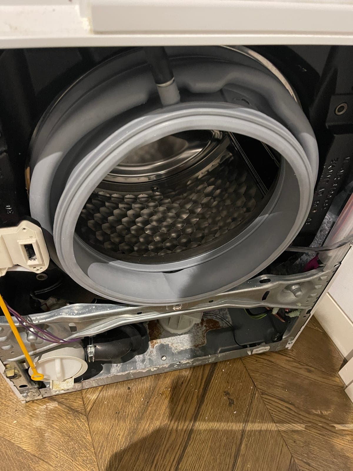A front loader with the front panel off for a door seal replacement.